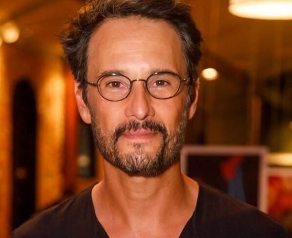 Rodrigo Santoro posa de óculos e blusa preta - Metrópoles