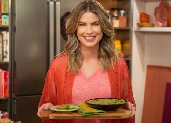 Foto colorida de Rita Lobo segurando pratos - Metrópoles