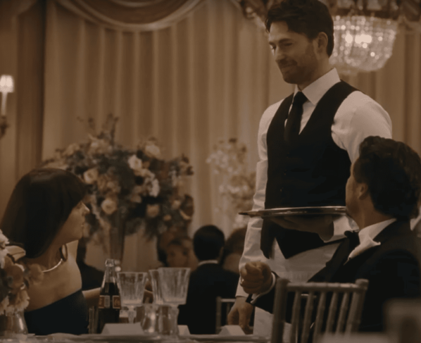 Imagem colorida - Dakota Johnson e Pedro Pascal (sentados) olham para Chris Evans (em pé) em Materialist